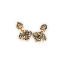 A pair of gold-toned dangle earrings with textured, organic-shaped charms and small heart-shaped studs, shown on a plain white background.
